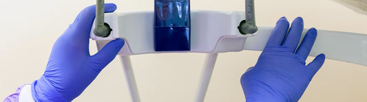 Person wearing blue nitrile gloves in a medical setting