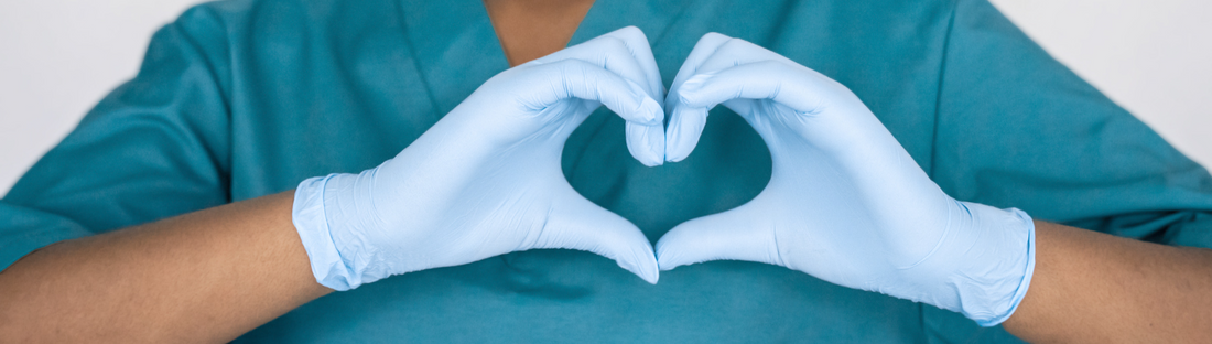 Person wearing blue nitrile gloves and making a heart