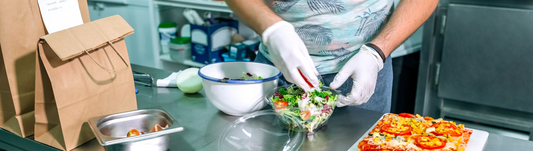 person wearing thin white nitrile gloves and doing food prep