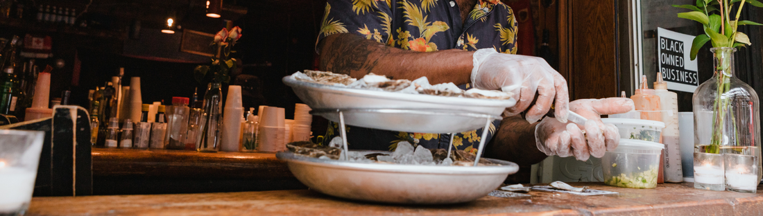 person wearing vinyl gloves and prepping seafood