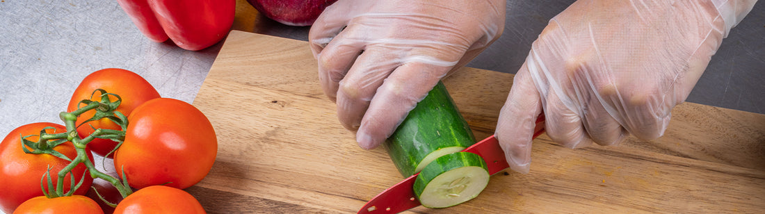 person wearing awear gloves and chopping a cucumber