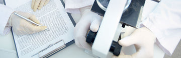 people wearing white latex gloves in a laboratory