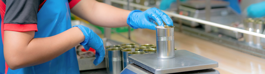 person wearing blue nitrile gloves and QA testing can at a factory