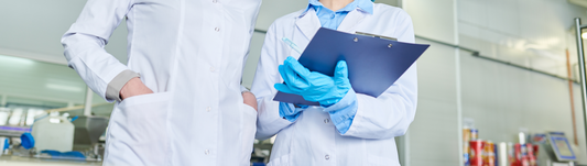 lady wearing blue nitrile gloves and taking notes in a food manufacturing facility