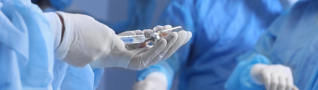 doctor's in OR room wearing blue isolation gowns and white disposable gloves