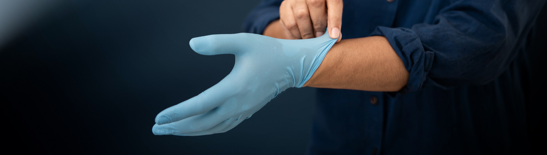 person pulling on light blue fitted nitrile glove