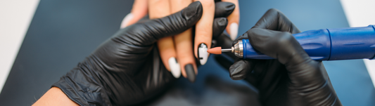 Person wearing black gloves and filing down gel nails