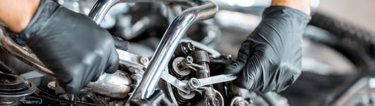 mechanic working on a machine while wearing black nitrile gloves